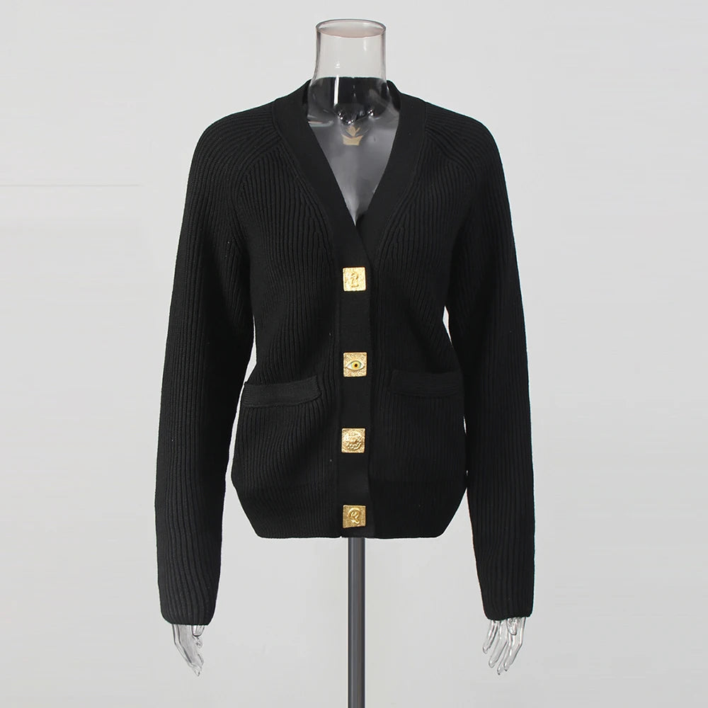 Black cardigan with gold buttons on a mannequin against a gray background