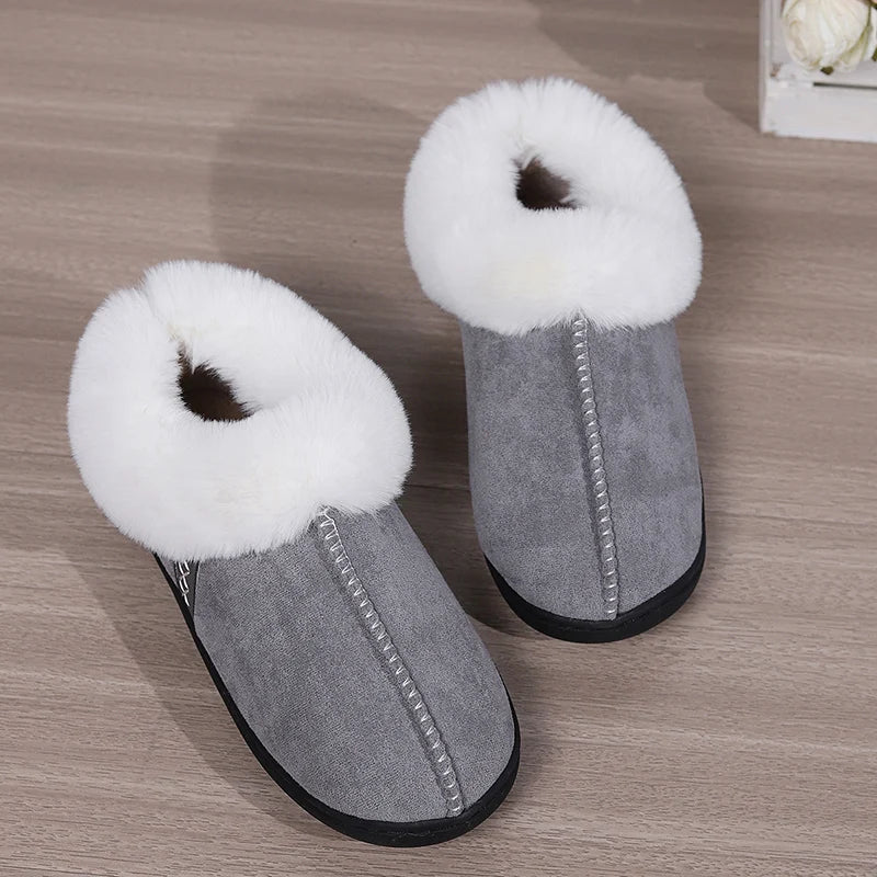 Gray slippers with white fur trim on a wooden floor