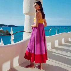 Side view of a contrast color strappy midi dress with defined waist and tiered hem