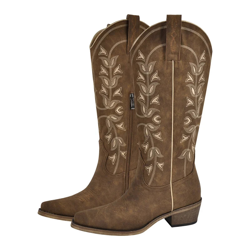 Brown cowboy boots with intricate white embroidery on a white background