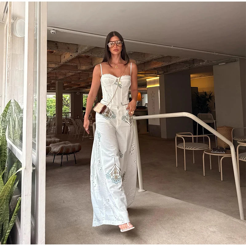 Floral print corset top and wide leg pants set on a model walking through a doorway.