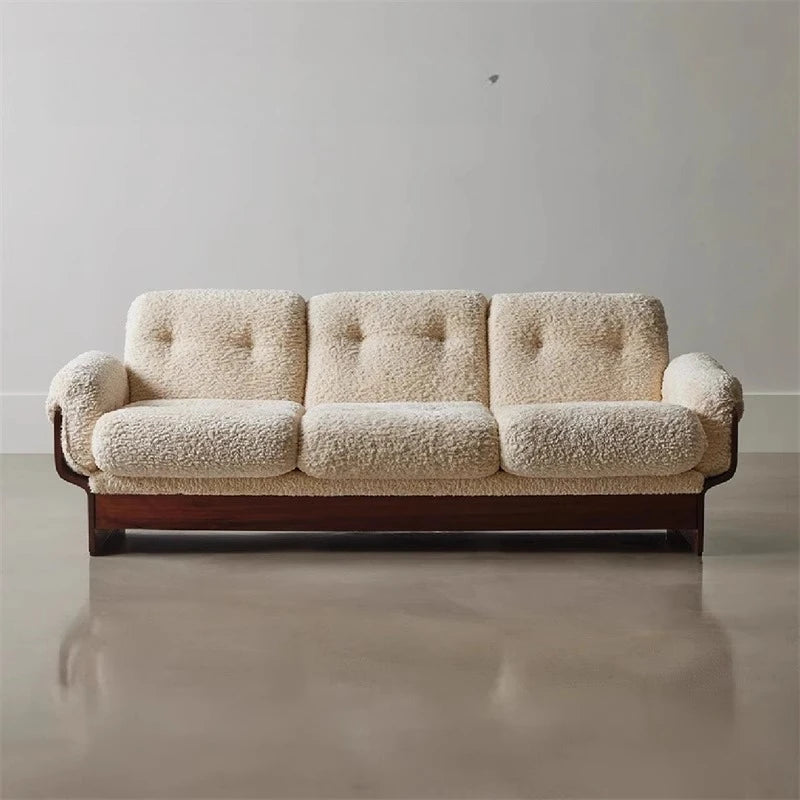 Beige bouclé modern sofa with walnut wood frame on polished concrete floor