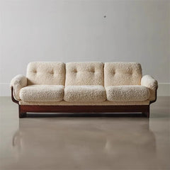 Beige bouclé modern sofa with walnut wood frame on polished concrete floor