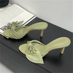 Twisted strap heeled slides in light green with a stiletto heel