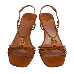 Close-up view of brown suede slingback heels showing beaded detail.
