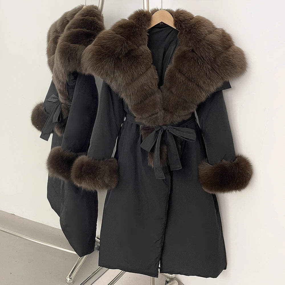 Black coat with fur trim and cuffs on a hanger against a white background