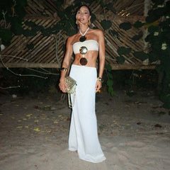 Model wearing strapless white swimwear with gold accents