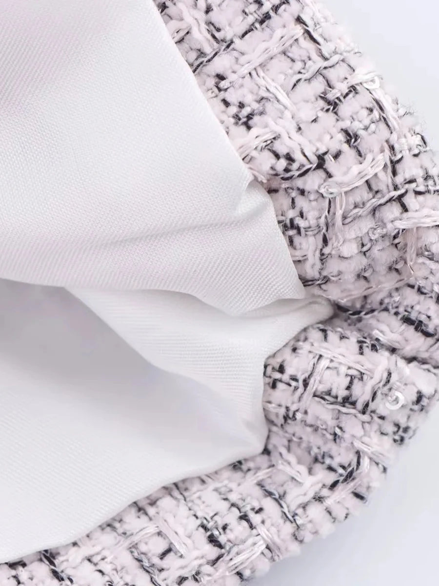 Close-up of textured fabric with a patterned edge on a light background