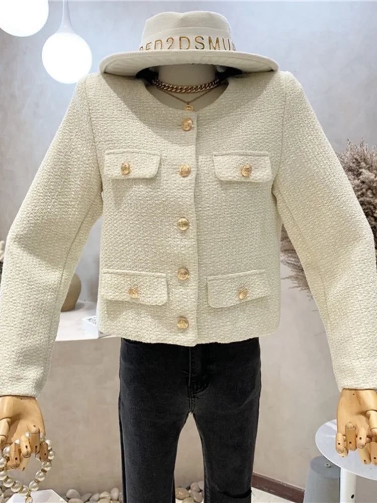 Mannequin wearing a cream-colored jacket with gold buttons and a matching hat.