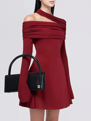 Red off-shoulder dress with a black handbag on a white background