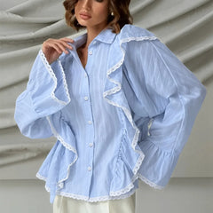 Light blue blouse with lace trim worn by a model against a neutral background