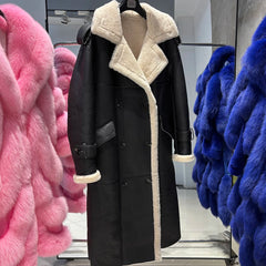 Black coat with white fur trim displayed in a store setting with pink and blue furs.