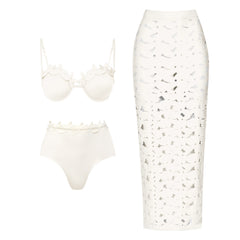 White bikini top and high-waisted briefs with floral-like embellishments and a matching white cutout midi skirt.