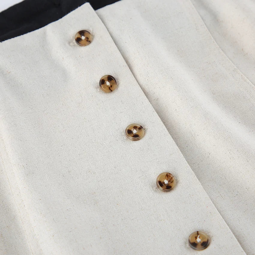 Close-up of a white fabric with gold buttons