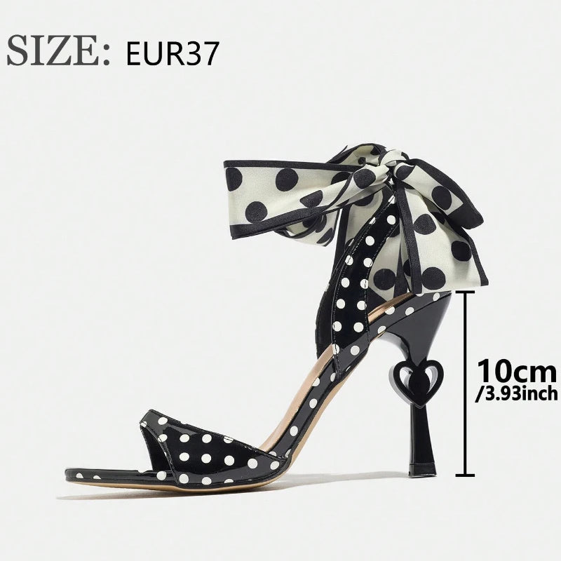 Black polka dot high-heeled shoe with a bow, size EUR37, on a white background.