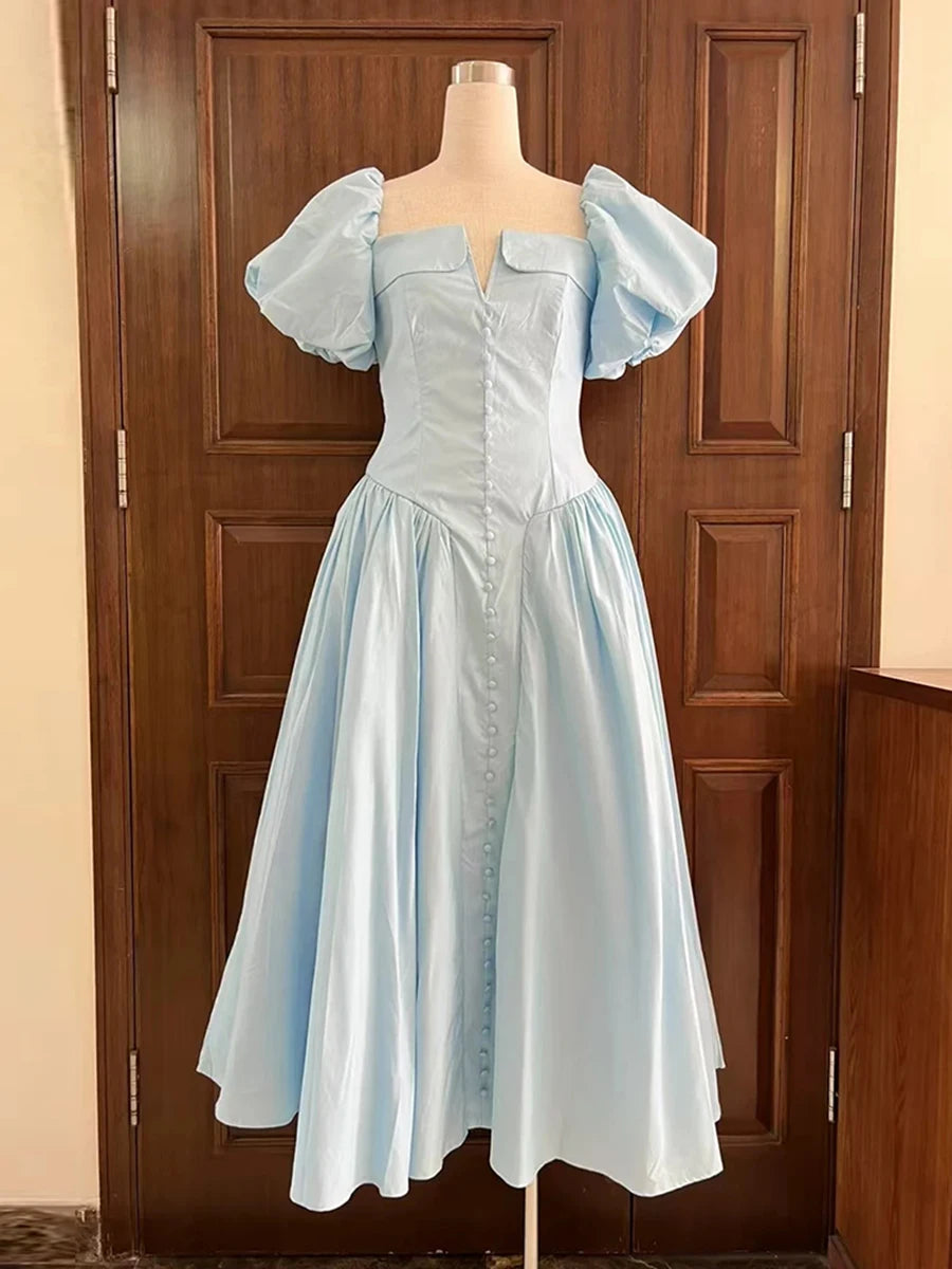 Light blue dress on a mannequin against a wooden door background