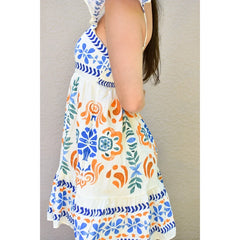 Colorful floral-patterned dress worn by a person against a neutral background