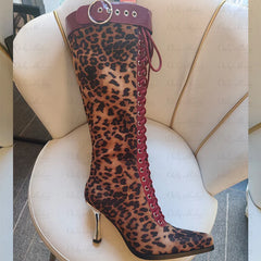 Close-up of a leopard print lace-up knee high boot with red accents