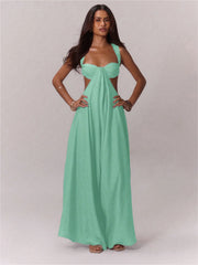 Woman wearing a green jumpsuit with a cut-out design on a plain background