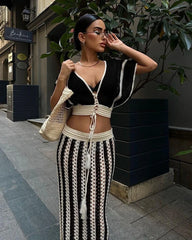 A model wearing a striped knitted dress set with a hollow-out long skirt and a V-neck crop top, posing on a street - Golden Atelier 2