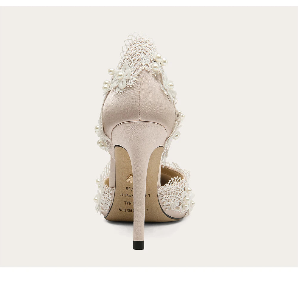 Beige high-heeled shoes with lace details on a white background