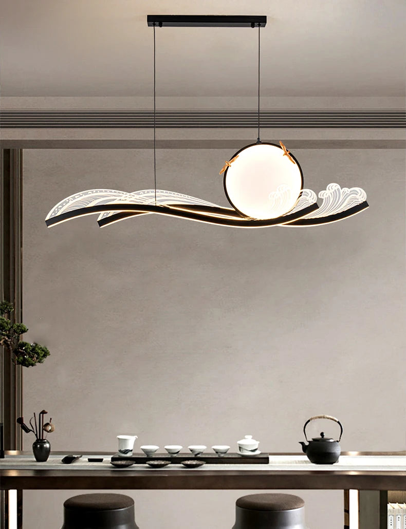 Modern pendant light hanging above a dining table with tea set