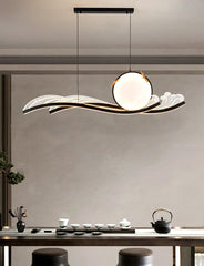 Modern pendant light hanging above a dining table with tea set