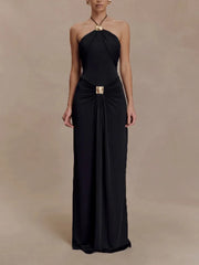 Black halter neck gown with a gold belt on a beige background