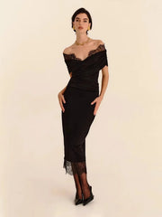 Woman wearing a black off-shoulder dress with lace details on a beige background