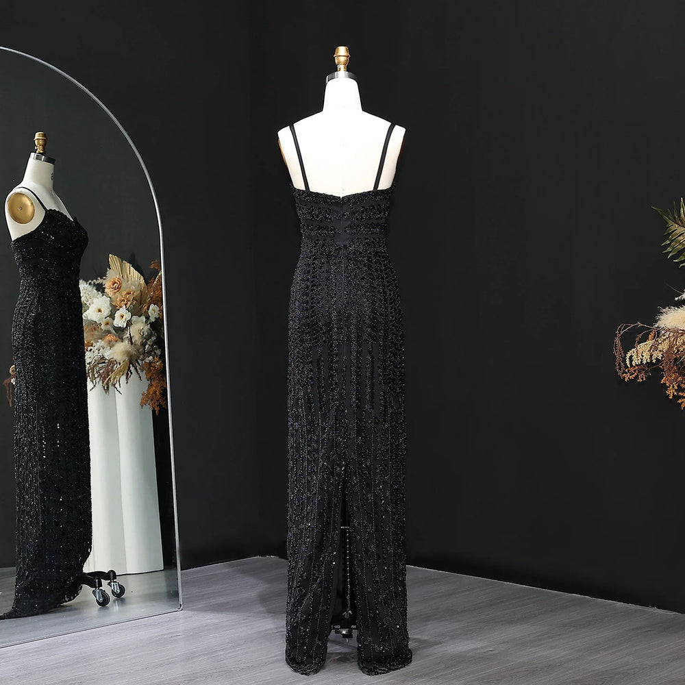 Black lace evening gown on a mannequin against a black background