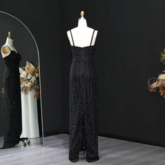 Black lace evening gown on a mannequin against a black background