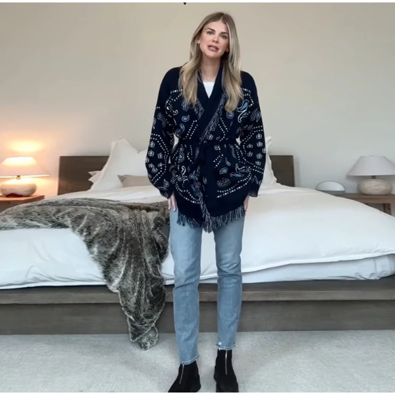 Woman wearing a dark blue patterned cardigan in a bedroom setting
