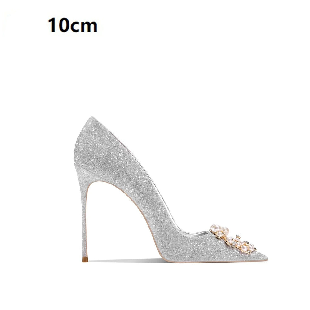 Silver high-heeled shoe with decorative elements on a white background