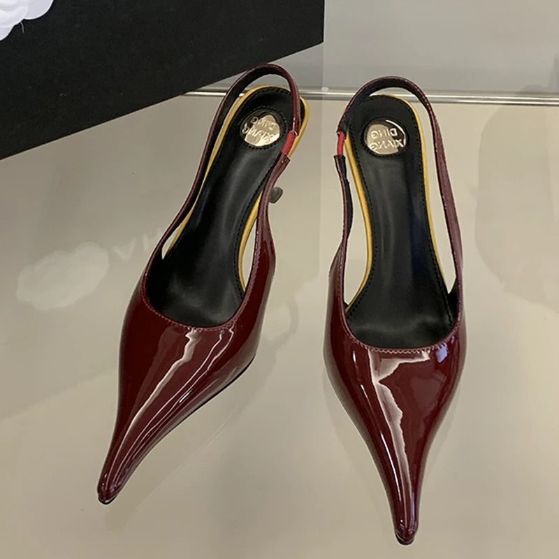 Pair of red high-heeled shoes on a reflective surface