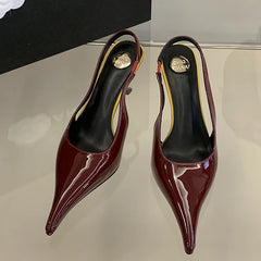 Pair of red high-heeled shoes on a reflective surface