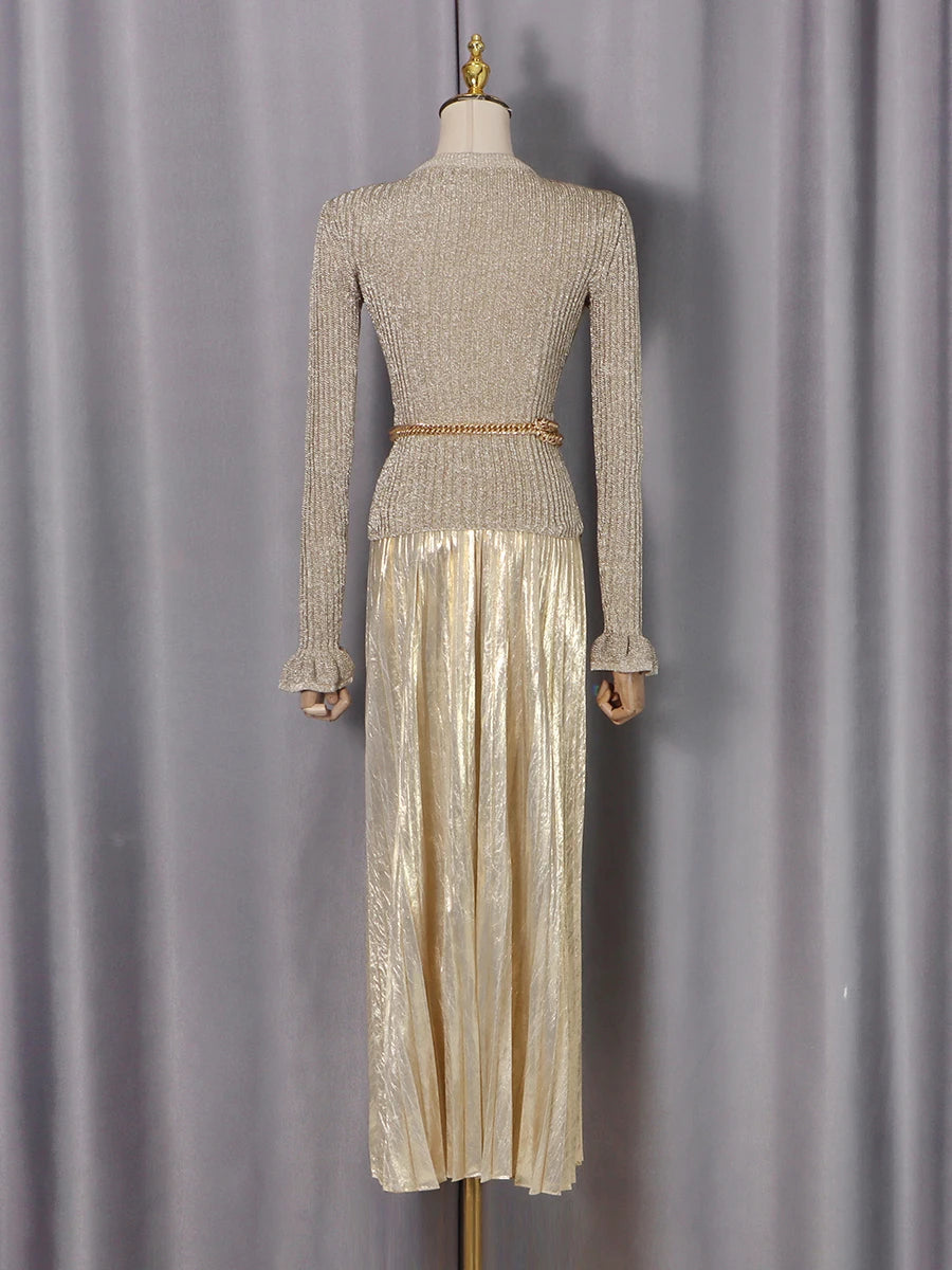 Mannequin wearing a two-piece outfit with a textured top and shiny skirt against a gray curtain background
