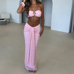 Woman wearing a pink strapless top and sarong in an indoor setting