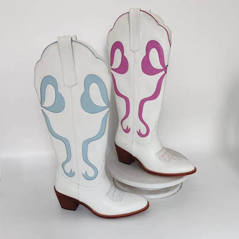 White cowboy boots with blue and pink designs on a white background