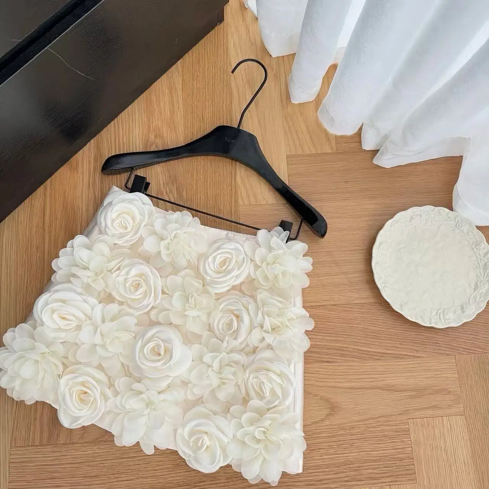 White floral skirt on a black hanger on a wooden floor