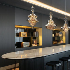 Modern brass chandelier with three glass pendant lights, illuminating a kitchen island. Golden Atelier 3