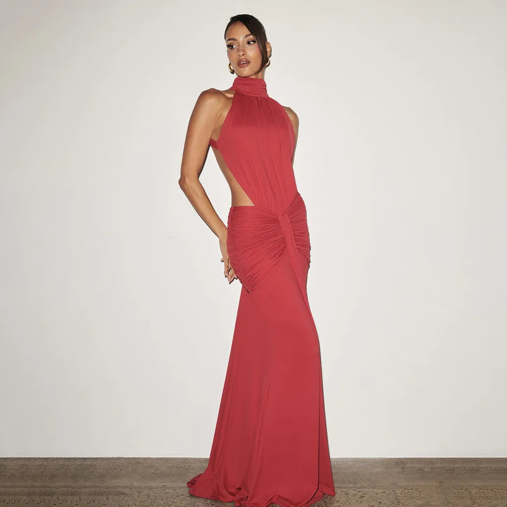 Woman wearing a red evening gown with cut-out design on a plain background