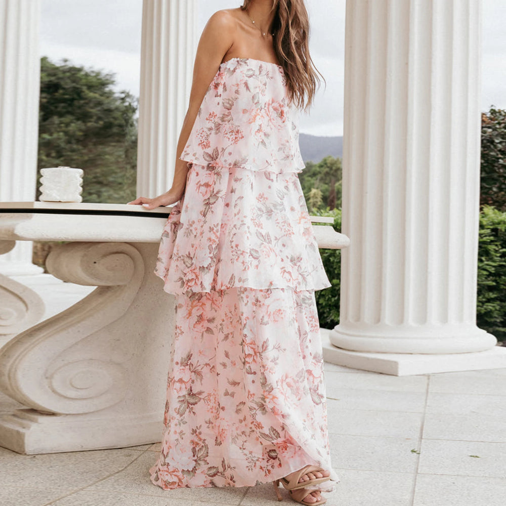 Woman wearing a floral dress standing in front of classical columns.