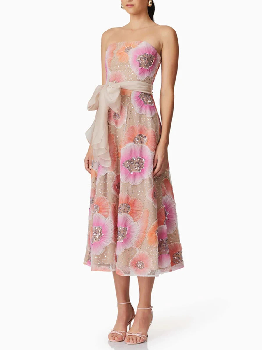 Woman wearing a floral strapless dress with a white background