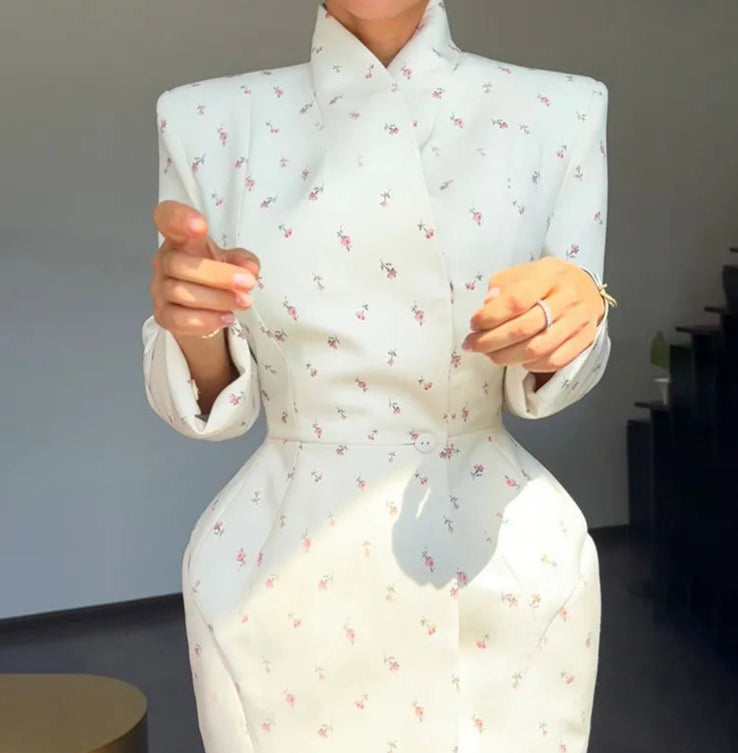 Person wearing a light blue floral dress with a blurred background