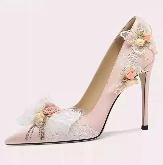 High-heeled shoe with floral decorations on a light pink background