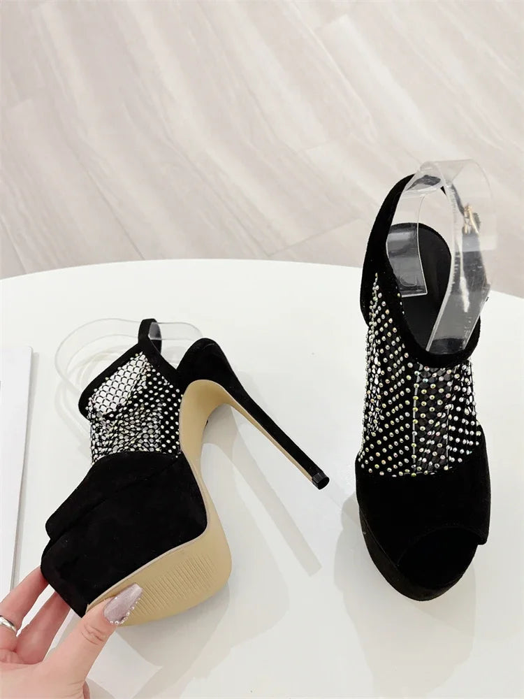 Black high-heeled shoes with rhinestone embellishments on a white surface.