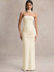Woman wearing a strapless, floor-length cream dress against a neutral background