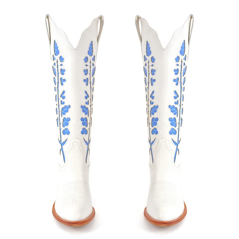 White cowboy boots with blue floral patterns on a white background