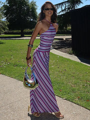 Woman wearing striped halter neck floor-length maxi dress with lace-up detail – perfect for summer parties or elegant night events