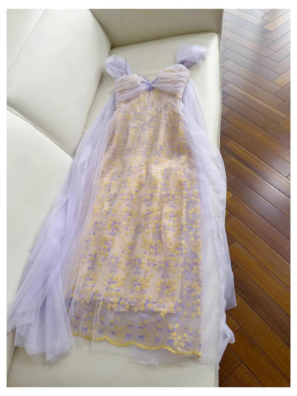Embroidered butterfly tulle overlay maxi dress laid on a white couch
